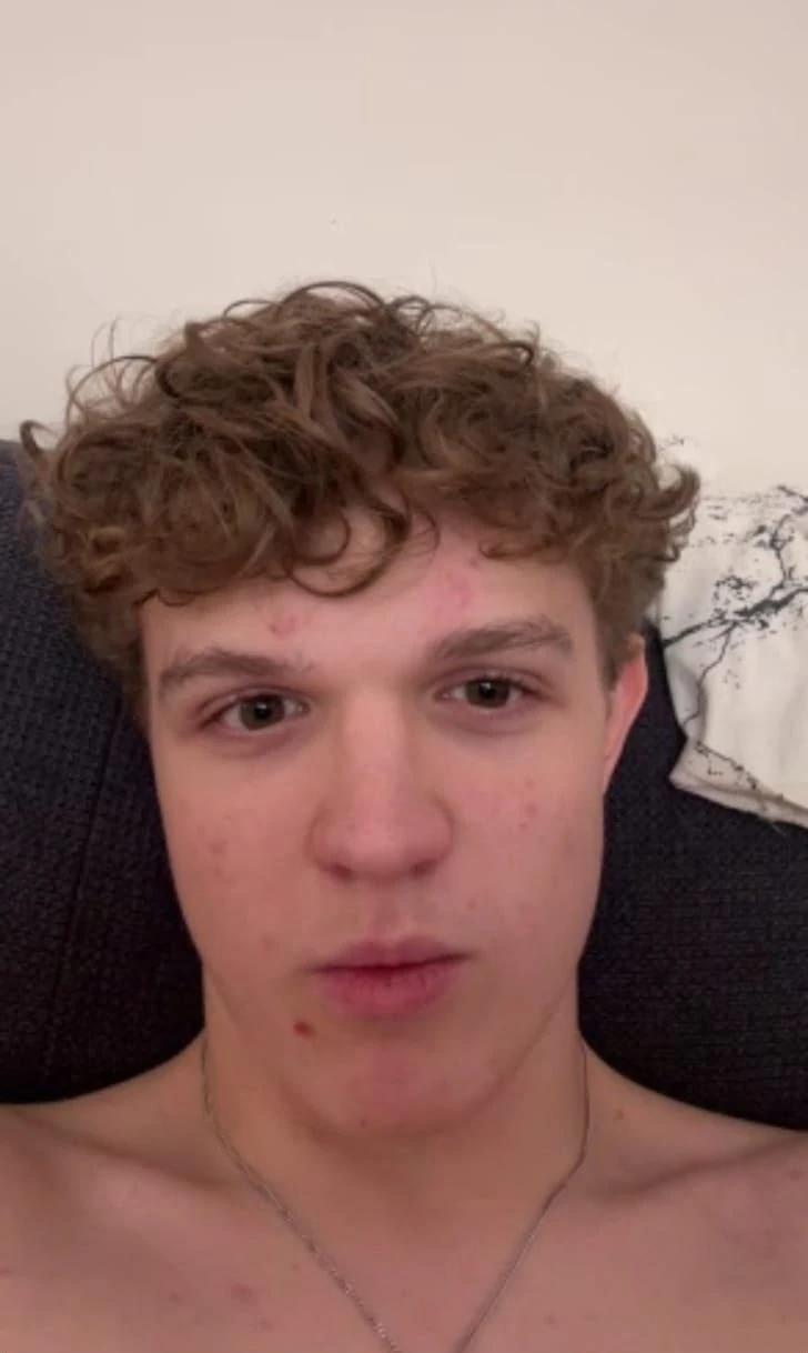 Sami with curly hair, relaxing on the couch