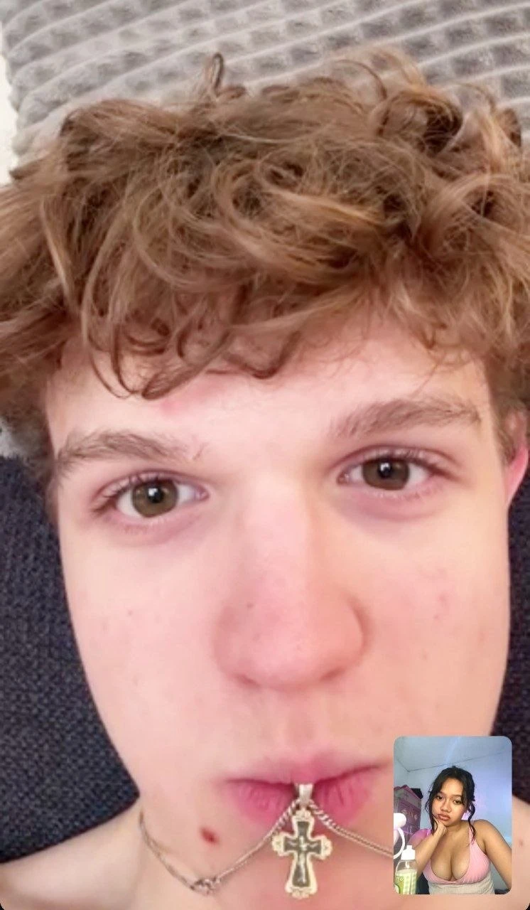 Sami holding his necklace near his lips during a video call with Elysia